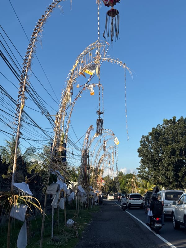 Traditional Penjor decorations line busy streets in Manggis, Indonesia