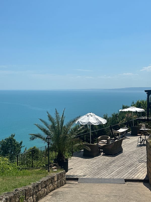 Coastal resort grounds with pools, terraces, and sea views