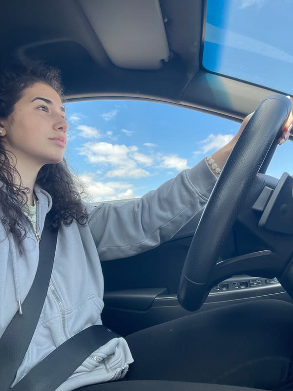 Woman gazes through sunroof while seated in car, Sofia
