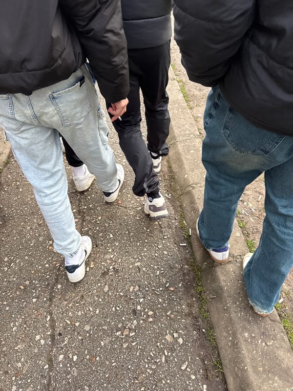 Three people gather on cigarette-strewn sidewalk in Troyan