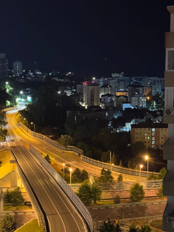 Nighttime aerial sweep over Sochi's highway interchange and residential towers