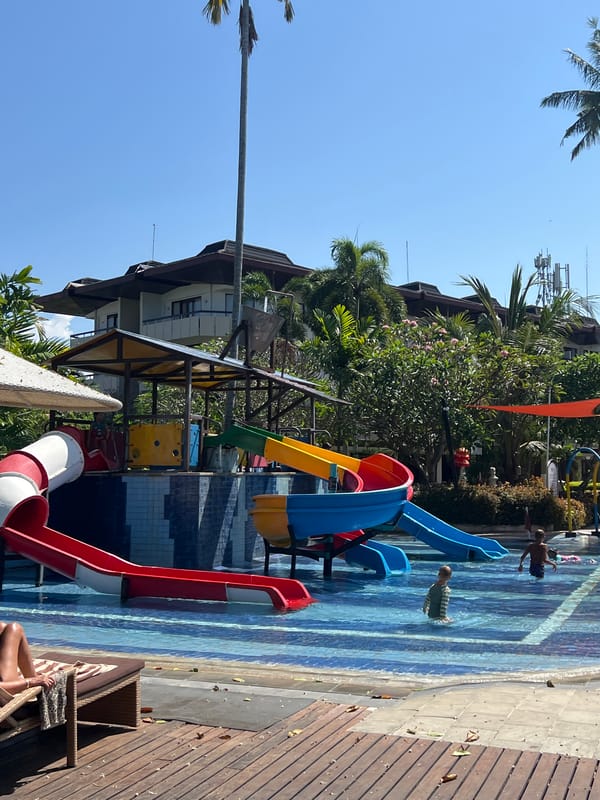 Beach resort morning in Denpasar — water park, surf school, and shoreline