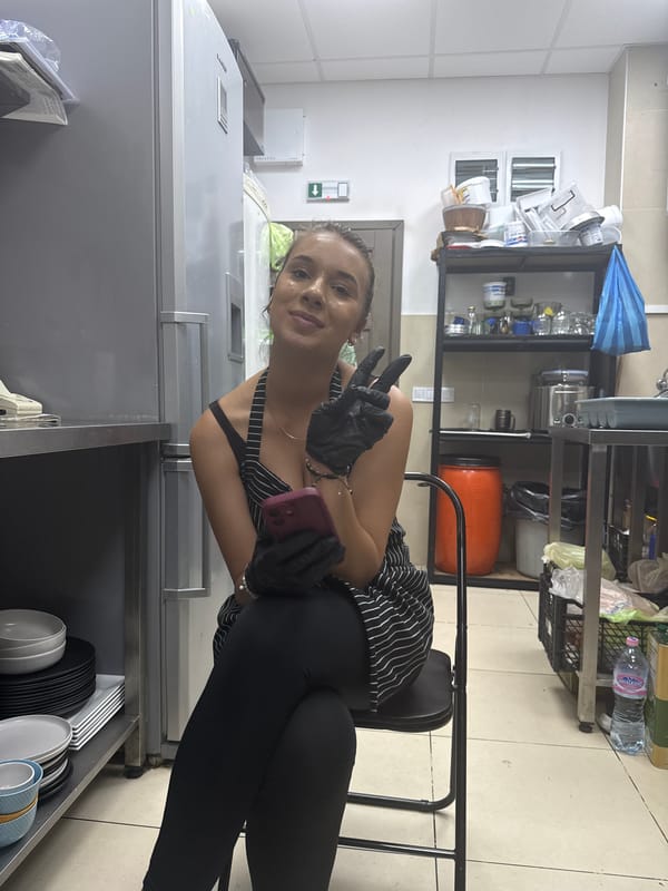 Gloved and aproned, phone in hand, in a Smolyan kitchen