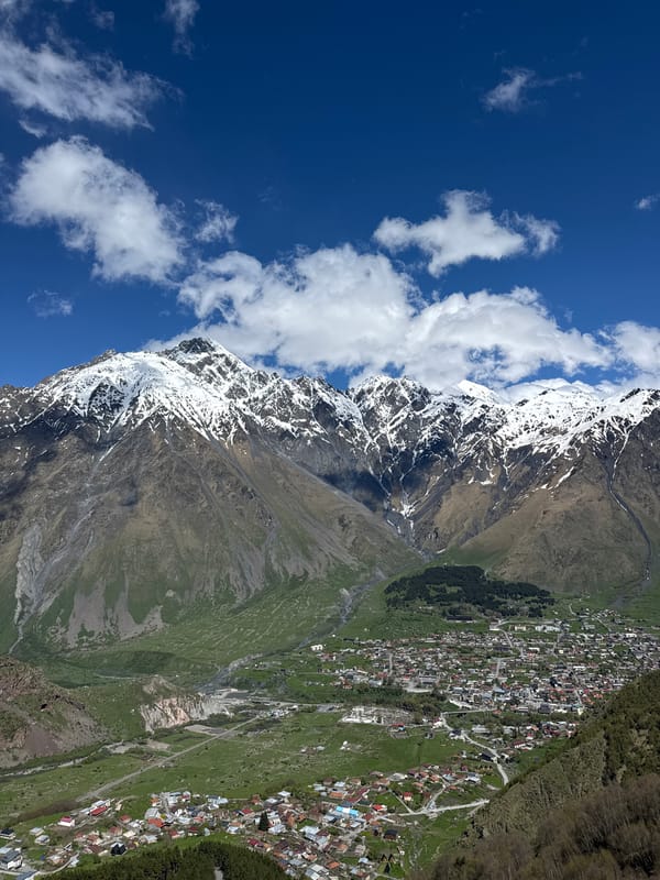 Tourist visits historic Gergeti Trinity Church in Georgian mountains