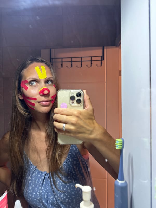 Woman applies colorful tape to face in Turkish bathroom