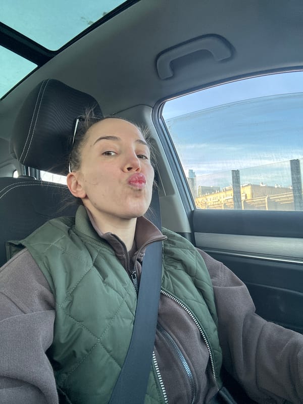 Young woman poses playfully in car passenger seat, Moscow