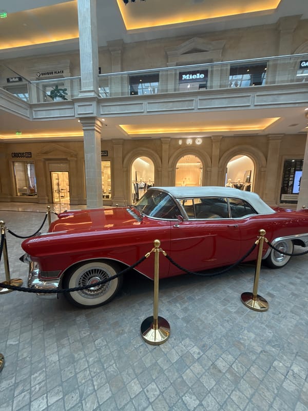 Vintage red Cadillac on display inside a grand indoor atrium