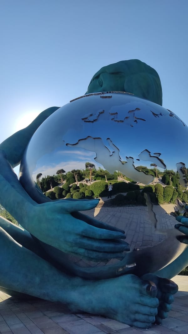 Teal globe sculpture monument in Krasnodar park setting