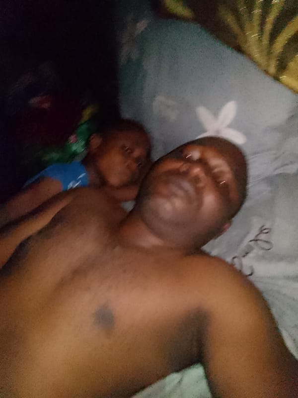 Family members rest together on bed in dark room