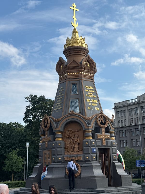 Ornate religious monument and street vendor in a Cyrillic-script city square