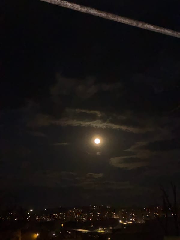 Full moon photographed through clouds in Yerevan night sky