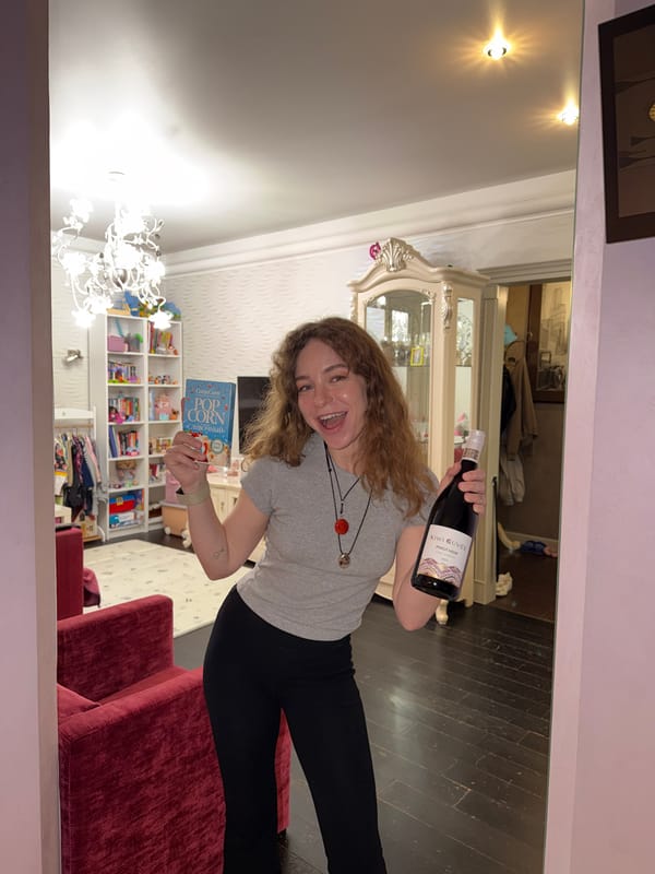 Woman poses with wine and popcorn in Moscow apartment