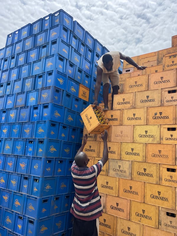 Men gather around beer crate stacks in Bukuru, Nigeria