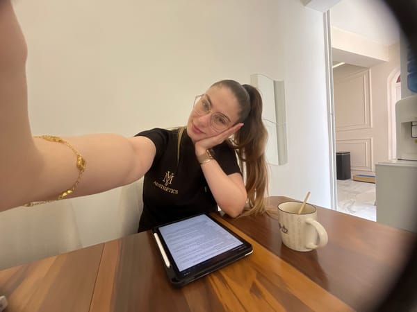Woman in scrub top takes selfies while working at desk