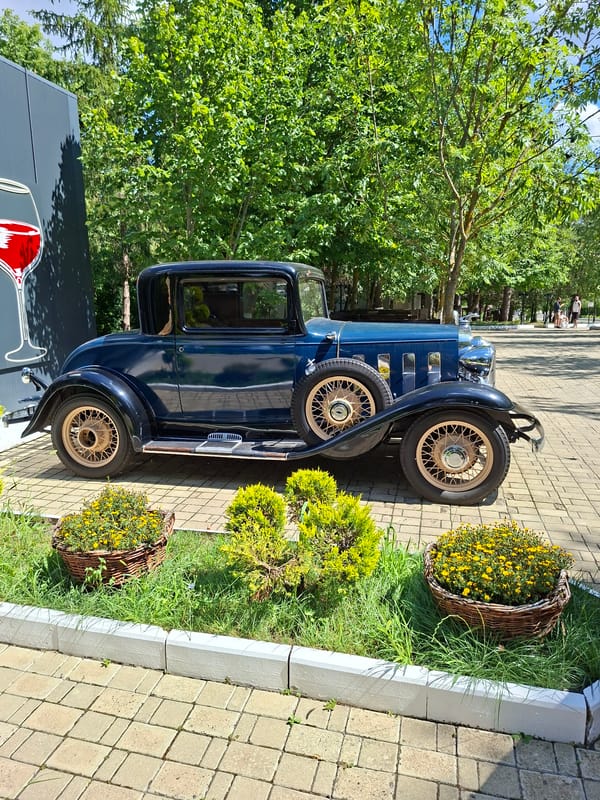 Vintage cars and wine barrel fountain at Milestii Mici winery