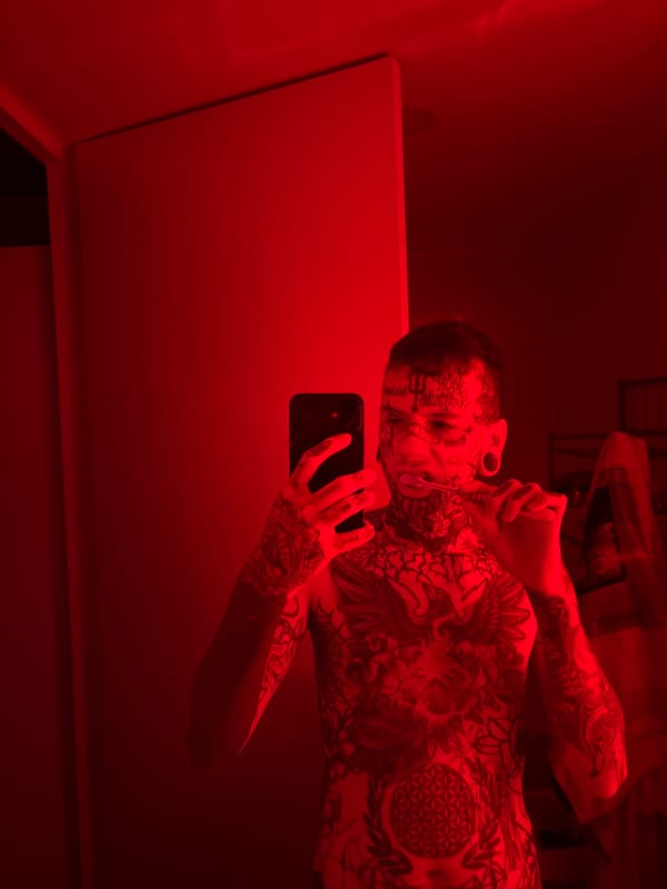 Tattooed individual takes bathroom selfie in Buenos Aires