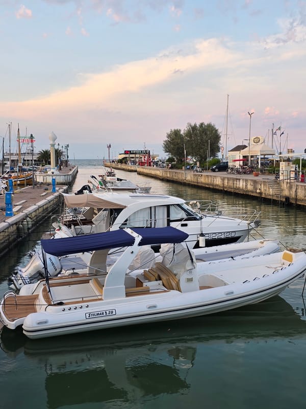Boats docked at sunset along Riccione's harbor promenade