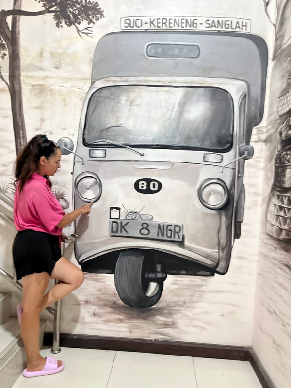 Posing across a stretch of black and white murals in Kuta Selatan