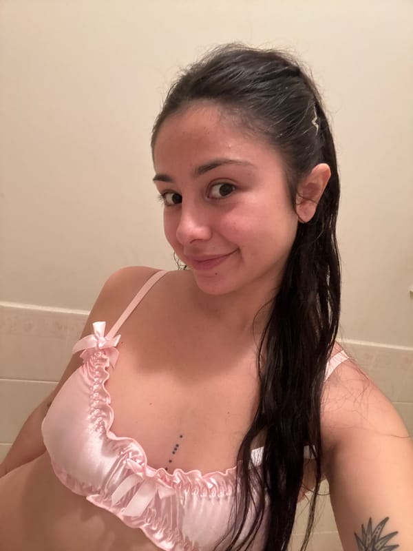 Woman photographs herself in pink outfit in Como bathroom
