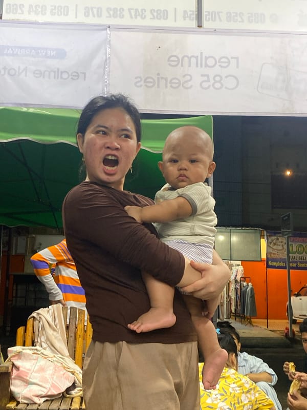 Evening family hangout outside shops in Ta', Indonesia