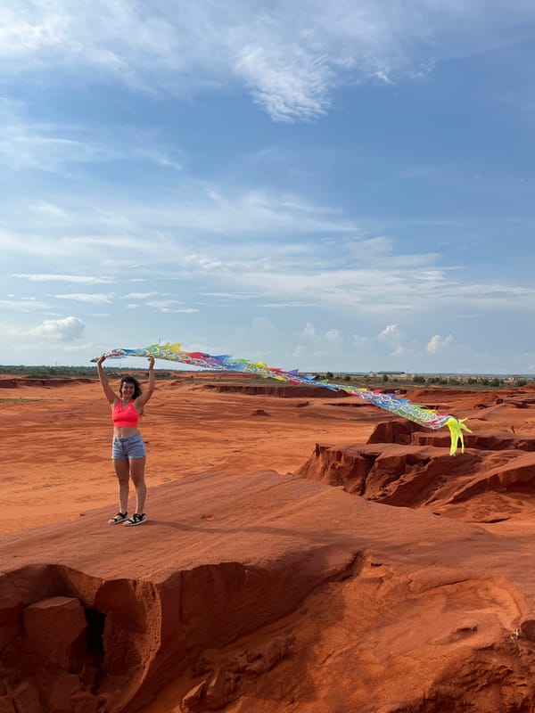 Kite flying at Mui Ne's red sand dunes on a clear morning