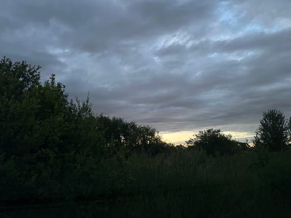 Storm clouds gather over Tallinn at dusk, chimney in frame