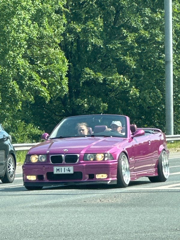 Highway drive past dealerships, pylons, and roadside landmarks