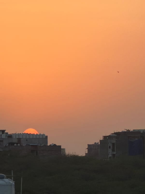 Delhi rooftop life captured during sunset with Qutub Minar views
