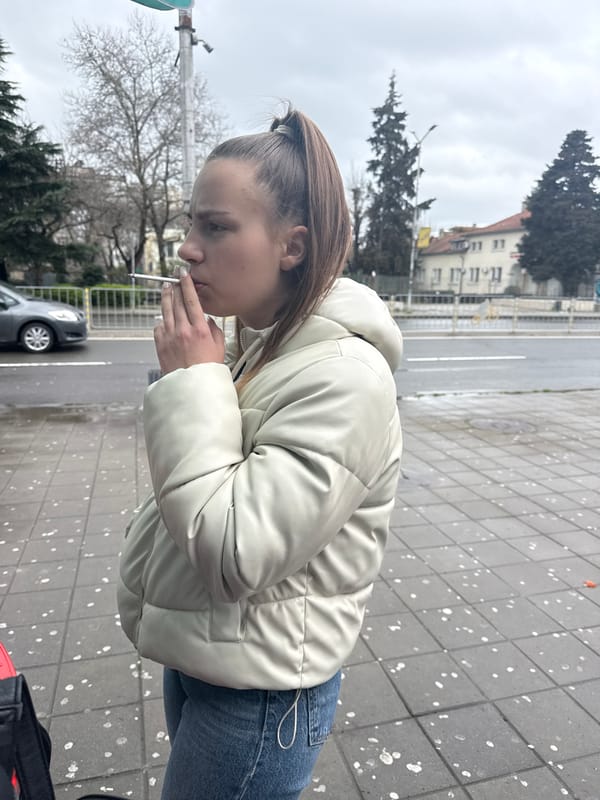 Woman smoking cigarette on sidewalk in Burgas, Bulgaria