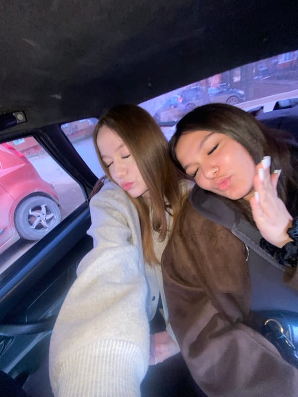 Two women take playful selfies in taxi in Votkinsk