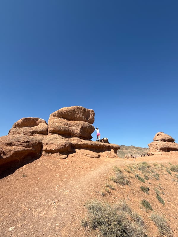 Pausing on a red rock ledge in Kazakhstan's canyon country