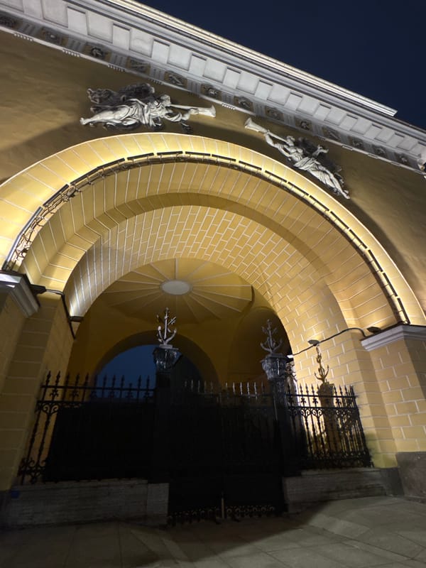Evening life captured around illuminated historic Saint Petersburg buildings