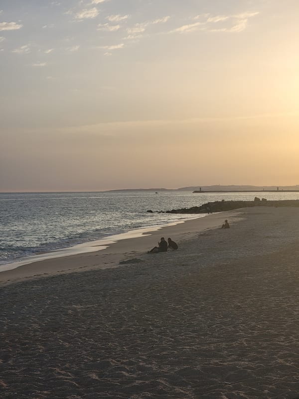 Sunset and crescent moon over Quarteira's beach promenade