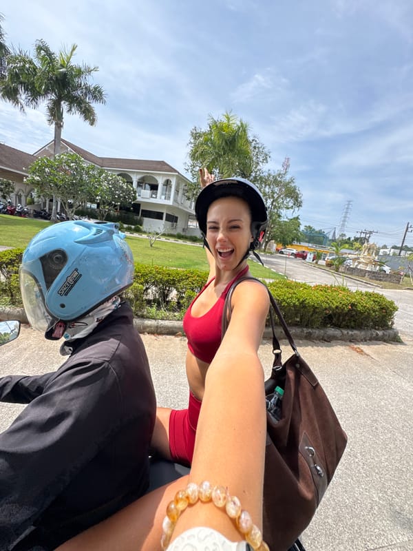 Person in anime shirt sits outdoors in Kathu, Thailand