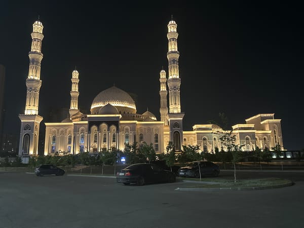 Astana mosque glowing under golden lights at night