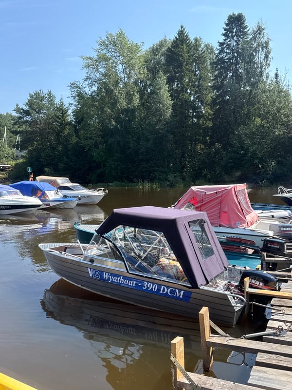 Quiet marina morning in Chaikovsky, boats docked and covered