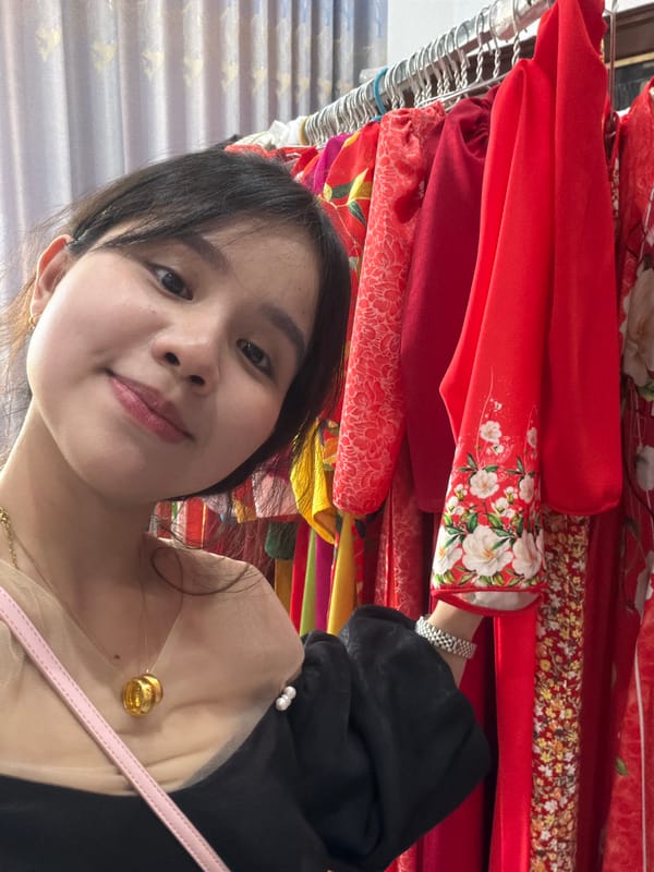 Woman takes selfie in busy clothing shop, Vietnam
