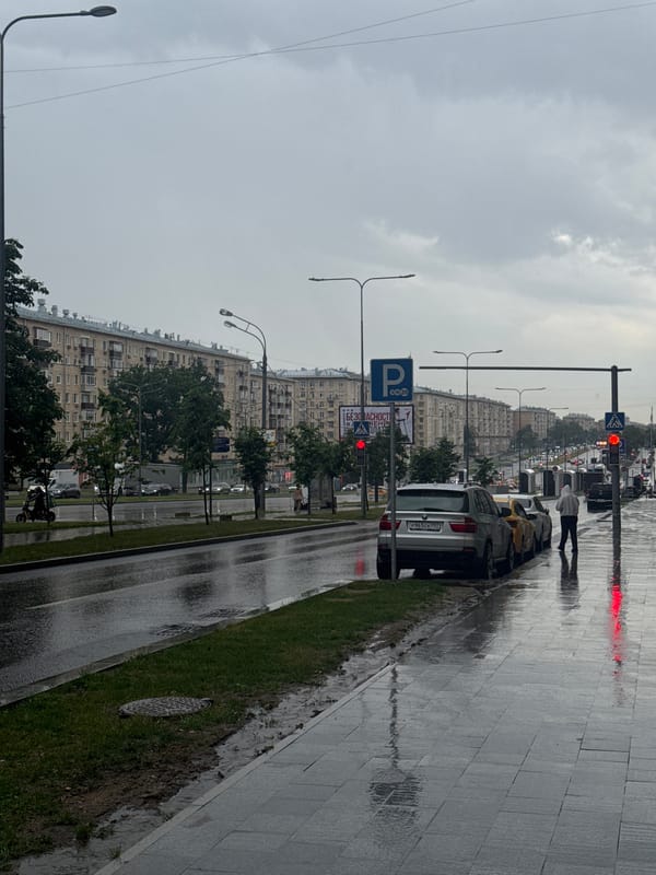 Rainy street scene with parked vehicles and umbrella perspective