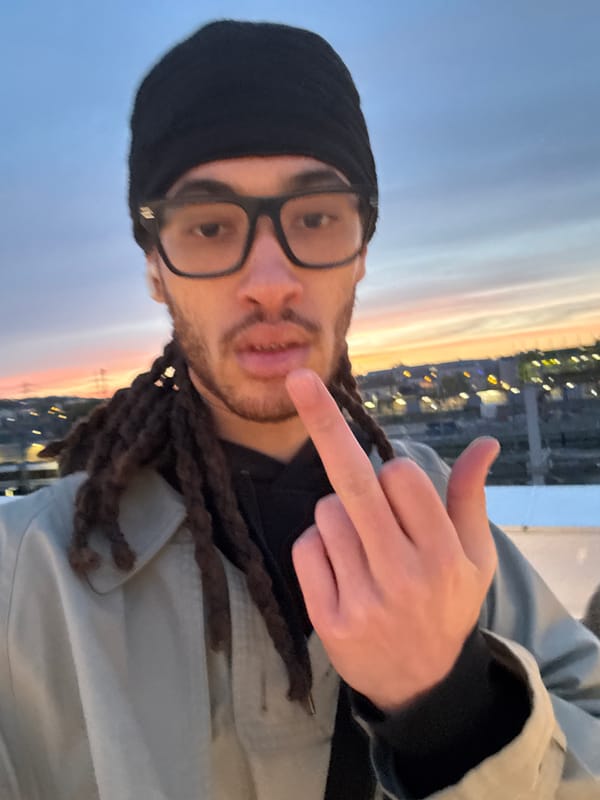 Man gestures near train yard during sunset in Massy