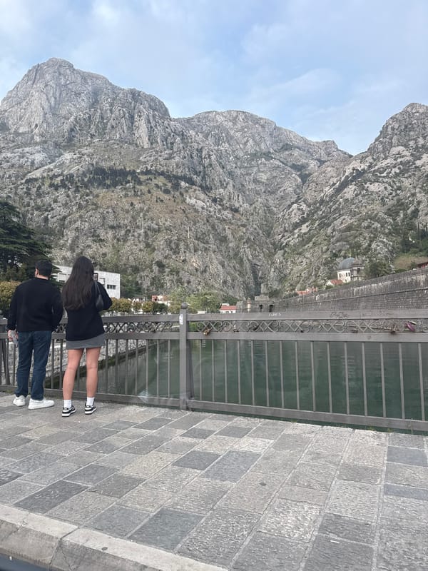 Couple sightseeing in Kotor while driver checks phone