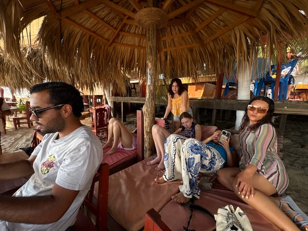 Friends gather at beach palapa in Brisas de Zicatela