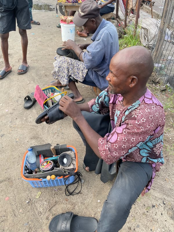 Morning street commerce and shoe repair in Ilado Nigeria