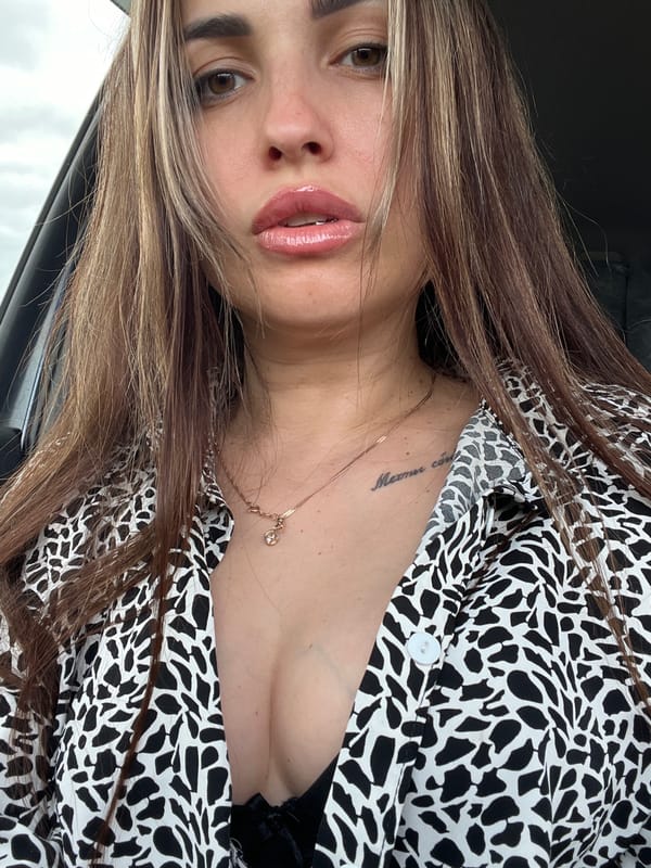Woman takes selfies during car journey in rural area