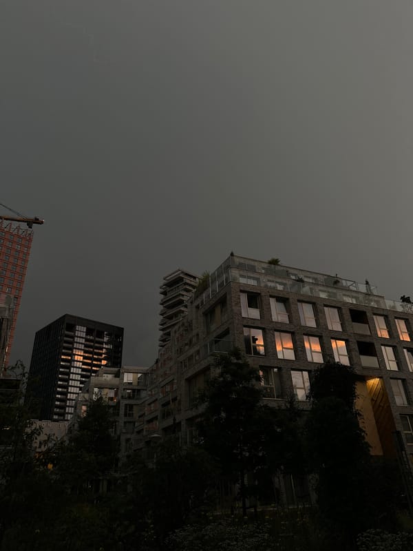 Amsterdam skyline under a stormy evening sky, crane and all