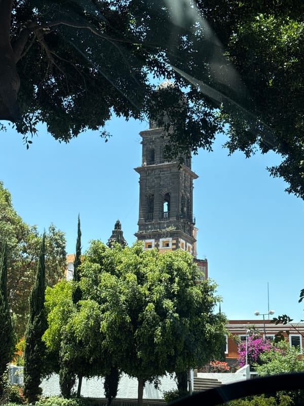Tourist documents bell tower and car selfie in Puebla