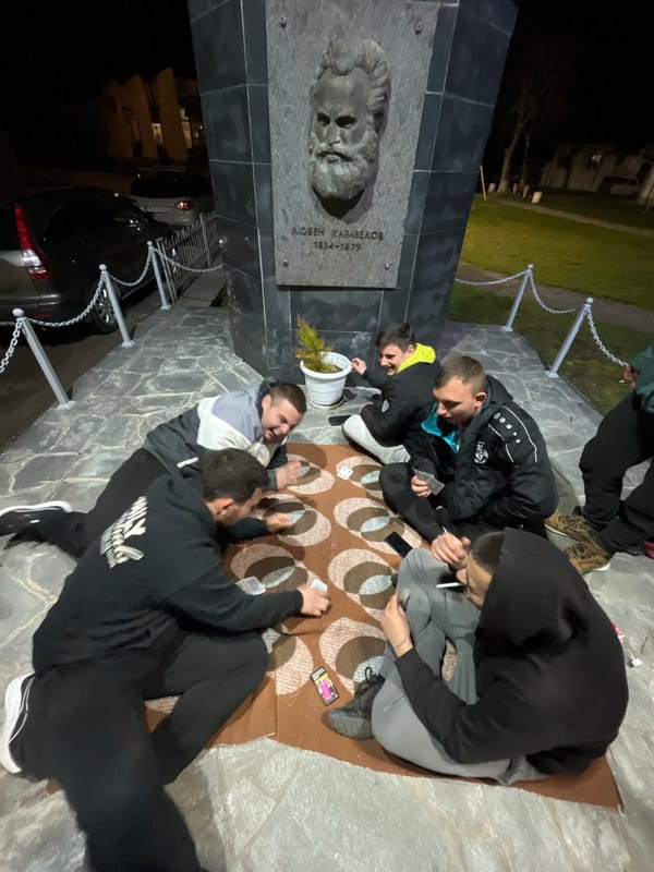 Young people play cards at Bulgarian monument at night