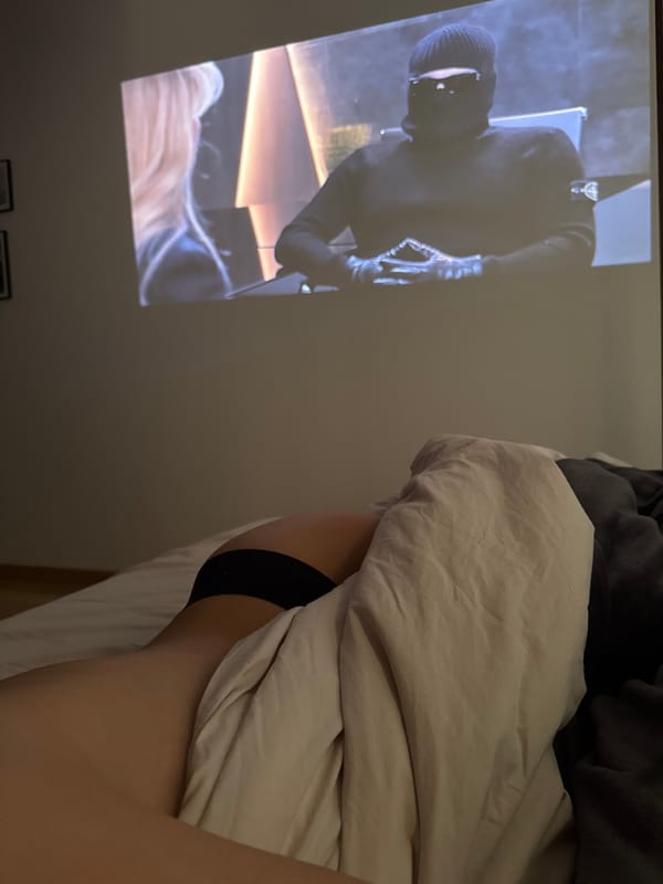 Person watches projected video while resting in Warsaw bedroom