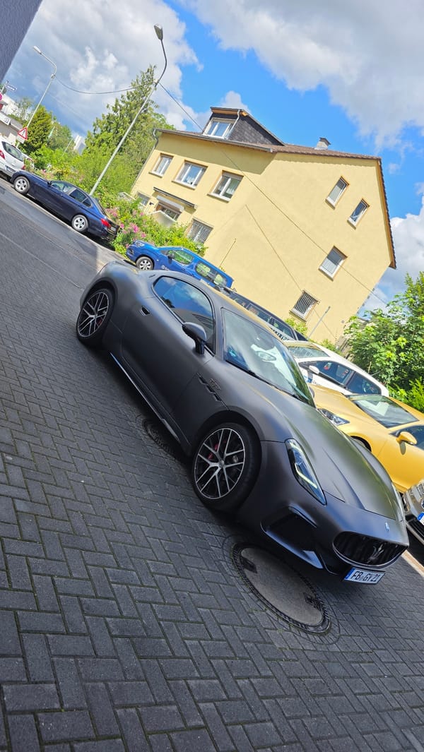 Luxury car gathering observed in urban brick-paved area