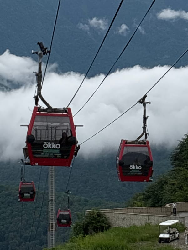 Busy day at a Caucasus mountain resort, cable cars and crowds