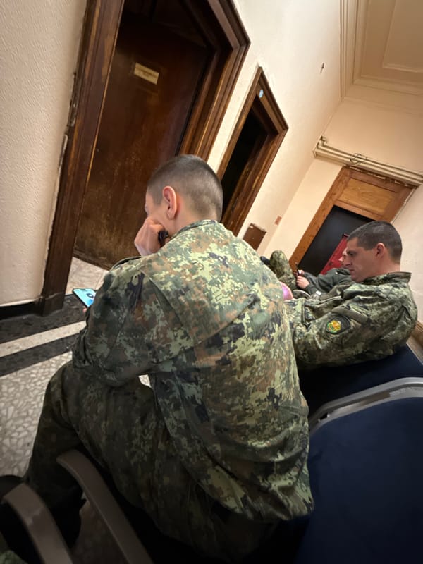 Military personnel using devices in Sofia hallway